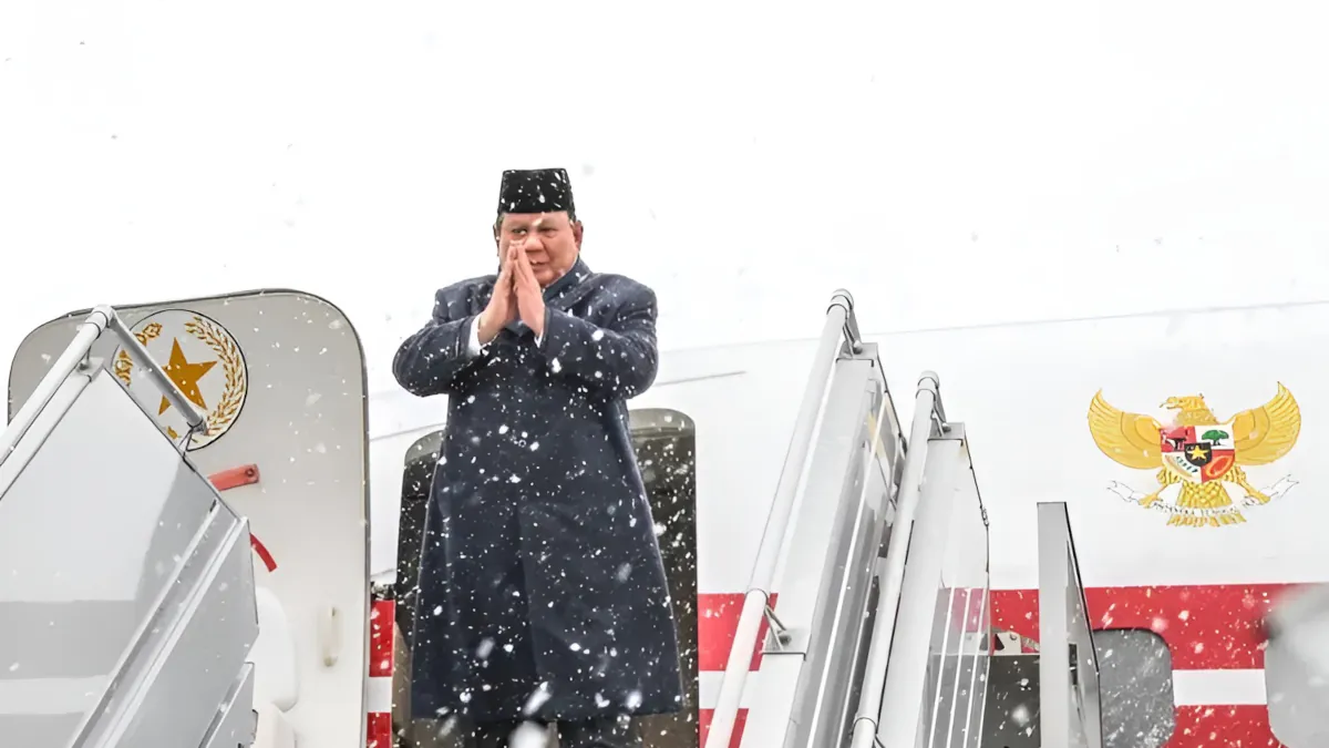 President of Indonesia, Prabowo Subianto, descends from the state aircraft amidst snowfall, offering a gesture of respect.